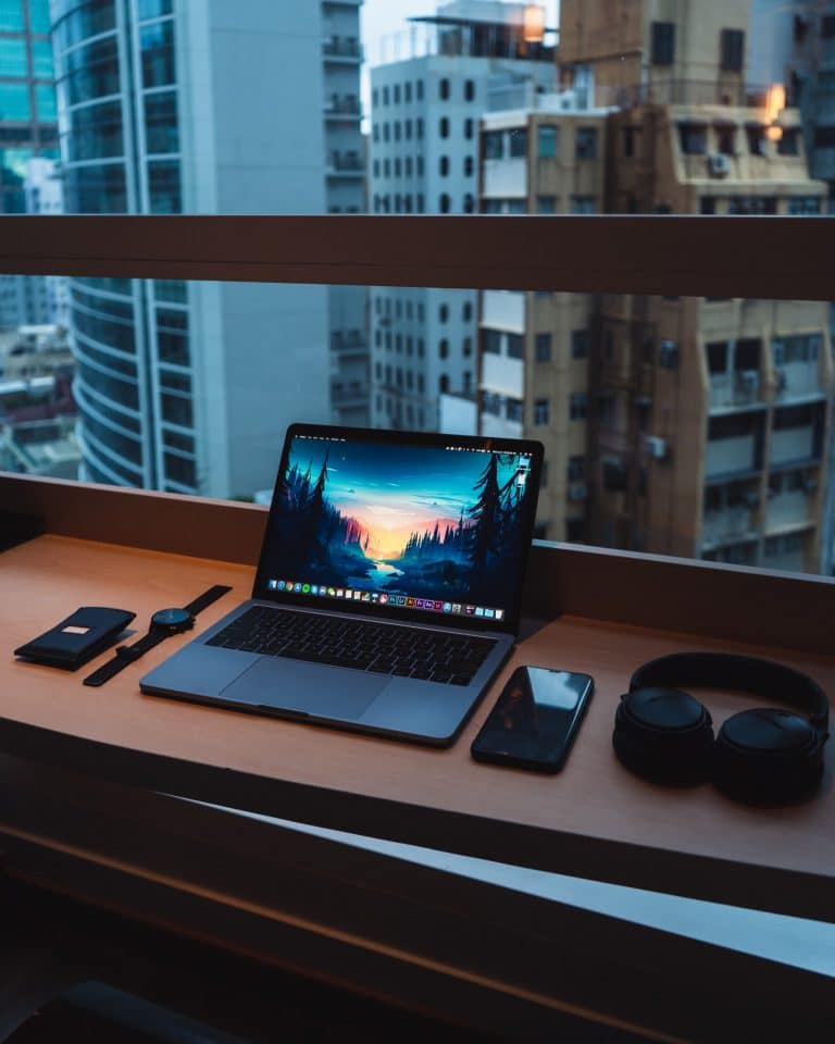 A computer at a desk by a window
