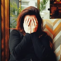 Woman covers her face.